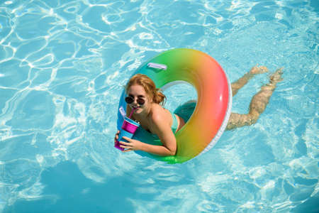 Summer Vacation. Enjoying suntan. Woman in swimsuit on inflatable circle in the swimming pool.