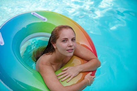 Summer woman in swimsuit on inflatable circle in the swimming pool.の写真素材