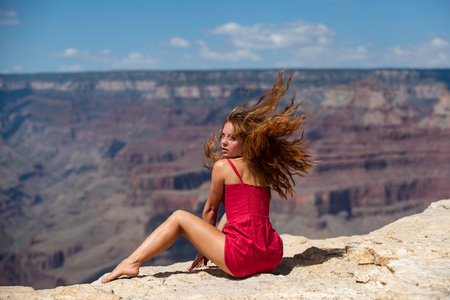 Travel and adventure concept. Elegant woman on grand canyon. Young Woman enjoying scenic dramatic view of american national park.の写真素材
