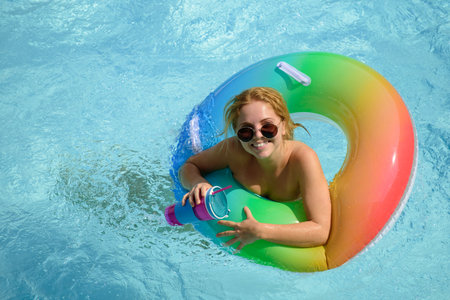 Girl summer vacation. Enjoying suntan. Woman in swimsuit on inflatable circle in the swimming pool.