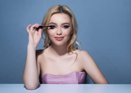Long eyelashes. Girl applying mascara. Makeup cosmetics. Woman beauty.の写真素材