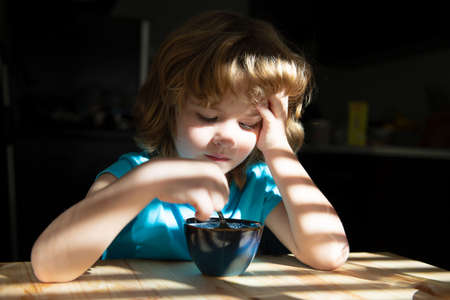 Healthy eating habits. Kids home food. Boy eats breakfast at kitchen. Children Nutrition.の写真素材