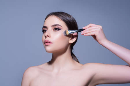 Makeup and cosmetics. Woman with makeup brush. Skincare. Visage. Beauty treatments.の写真素材