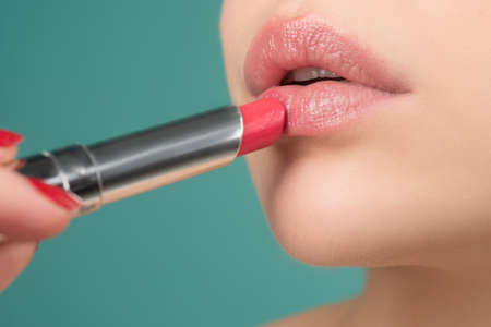 Beauty concept. Closeup lip lipstick. Applying lips makeup. Pampering, lips correction concept.の写真素材