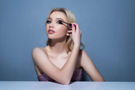 Girl applying mascara. Makeup cosmetics. Woman beauty. Fresh soft skin. Long eyelashes.