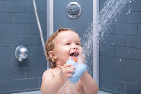 Happy funny baby bathed in the bath. Child in shower.の写真素材