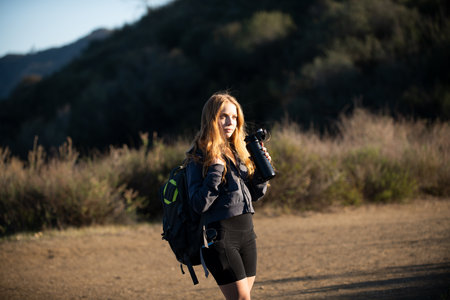Tourism concept. Woman hiker with backpack at hills. Tourist girl hiking in mountains with...