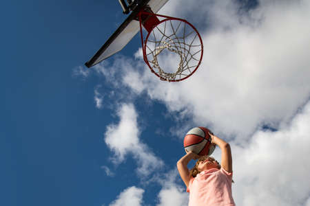 Kid boy concentrated on playing basket ball.の写真素材