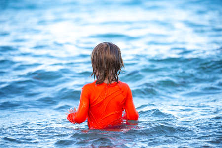 Happy child playing in the sea. Kid boy on the beach. Summer vacation and healthy kids concept.の写真素材
