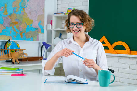 Happy school woman teacher in classroom. Education and Teachering concept.の写真素材