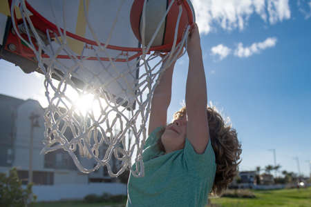 Basketball kids game. Cute little child boy holding a basket ball trying make a score.