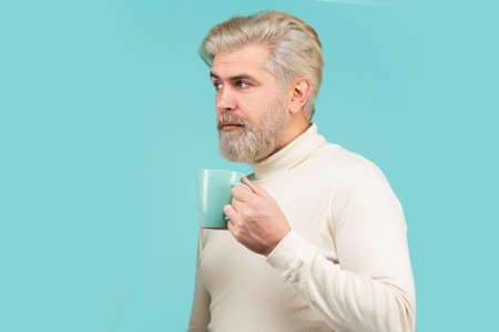 Good morning. Bearded man drinking espresso coffee. Handsome male holds cup of tea. Barista concept.の写真素材
