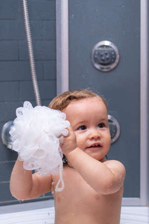 Child in shower. Baby showering. Portrait of kid bathing in a bath with foam.