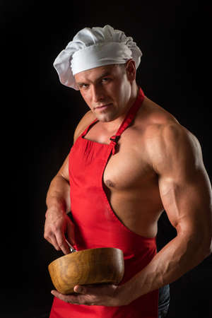 Sexy cooking man in apron. Muscular chef with bowl. Sports diet.の写真素材