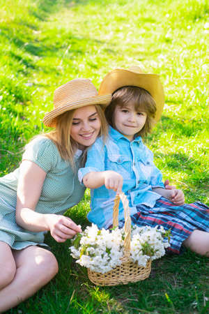 Happy mother day with son at picnic. Family mom with kid sitting on the grass in park.の写真素材