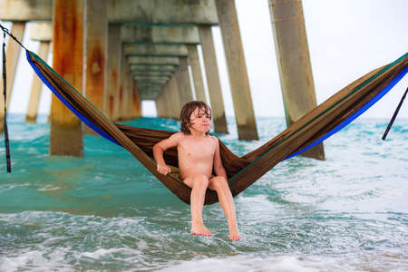 Summer vacation, kid boy in colorful hammock in sea.の写真素材