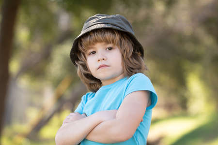 Happy baby boy standing in grass on the fieald with dandelions at sunny summer evening. Smiling child outdoorsの写真素材