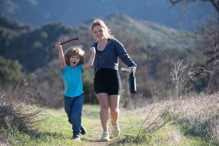 Children walking in mountain hills. Brother sister hiking in the park with beautiful sunlight. Boy girl family.の写真素材