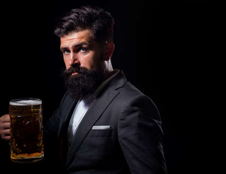 Portrait of serious man holds craft beer isoalted on black, copy space.