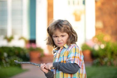 Kids conflict. Child aggression. Negative emotion concept. Angry bully boy with danger stick. Kid adaptation. Bullying concept. nervous breakdown.の写真素材