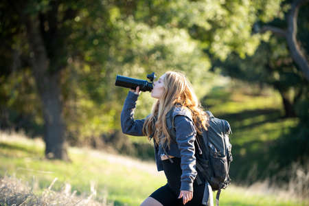 Woman traveler looking at Batur volcano. Indonesia. Female hiker with backpack at mountain. Girl...