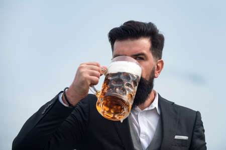 Elegant man drinking beer. Drink glass of beer.