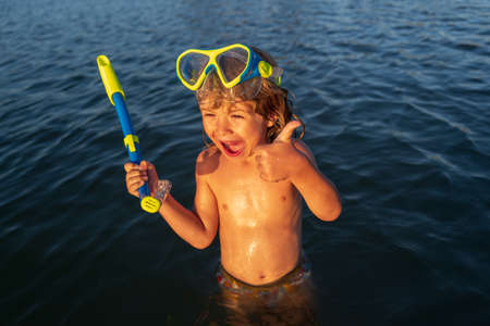Boy kid swimming on the beach on summer vacation. Child in sea. Happy children swimming and snorkeling in tropical ocean or seaside.の写真素材