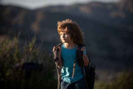 Kid with backpack hiking in scenic mountains. Boy local tourist goes on a local hikeの写真素材