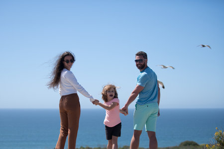 Happy family on the beach. People having fun on summer vacation. Father, mother and child on blue sea. Carefree family concept. Parents with kid relax outdoor. Family travel, vacation concept.の写真素材