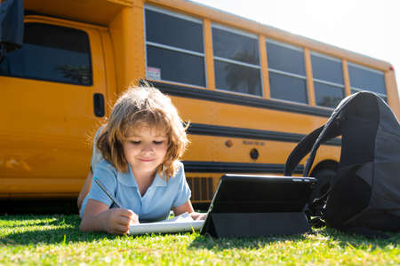 Back to school. Happy child study in park. School boy doing homework or online education.