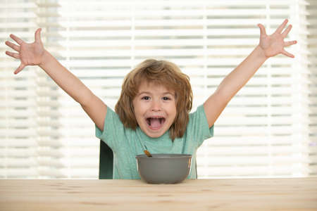 Funny excited kid with plate of soup. Child funny dinner.