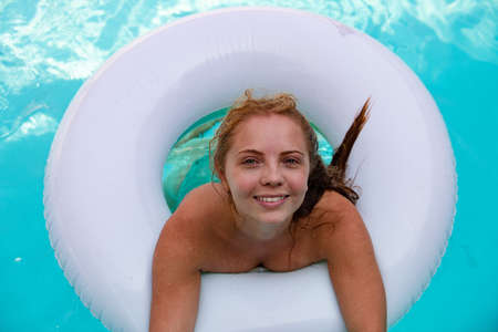 Summer Vacation. Woman in swimsuit on inflatable circle in the swimming pool.の写真素材