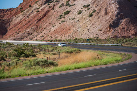 View of highway road running through the barren scenery of the American Southwest with extreme heat haze in summer.の写真素材