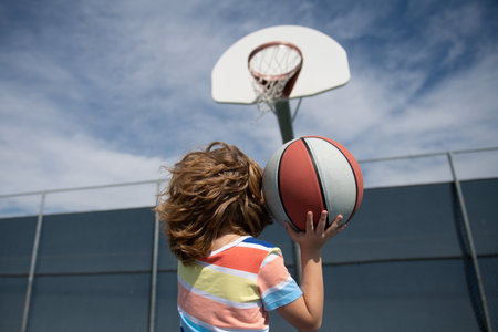 Little child boy playing basketball with basket ball. Basketball kids school.