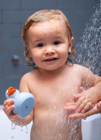 Bathing baby. Happy kid with soap foam on head. Kid shower.の写真素材