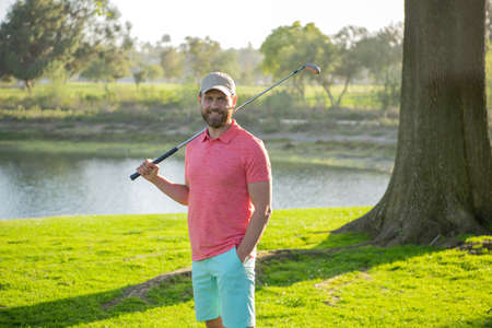 Golfer hitting golf shot with club on course.の写真素材