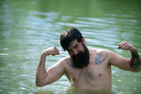 Bearded man on summer holidays. Male swimming in water. Having fun.