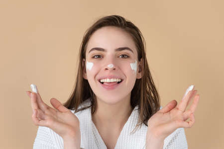 Beauty portrait of beautiful female model applying face cream. Woman with beauty face, natural skin, facial skin portrait.の写真素材