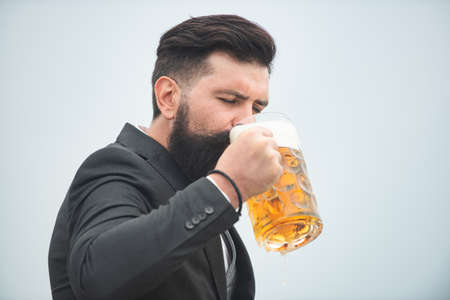 Barman holding a pint of beer. Hipster man drinking beer.の写真素材