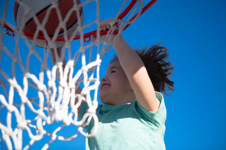 Basketball kids game. Cute little child boy holding a basket ball trying make a score.の写真素材