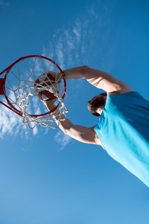 Basketball player shooting ball in hoop outdoor court. Urban youth game. Concept of sport success, scoring points and winning.の写真素材
