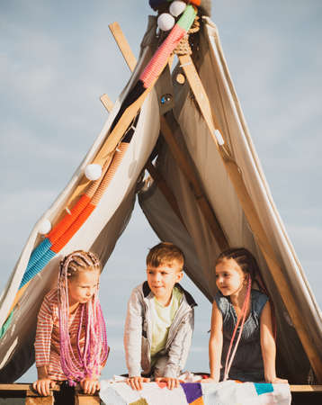 Happy friends camping. Kids in tent outdoor. Happy childhood concept. Children adaptation. Summer...