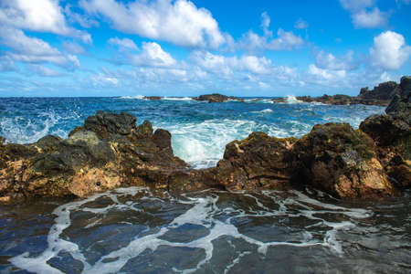 Sea stone beach, sea waves. Colorful blue sea background. The concept of summer vacation and travel. Clear sea water, large stones on the beach.の写真素材