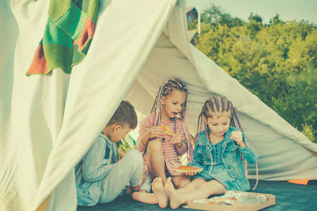 Children eating pizza. Italian junkfood. Friends eating tasty pizza. Kids favorite food. Fastfood for kids.の写真素材