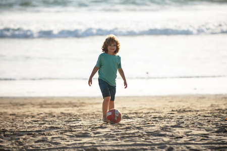 Child boy play football on sand beach.の写真素材
