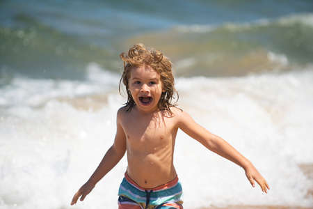 Excited little kid boy playing at the sea beach.の写真素材