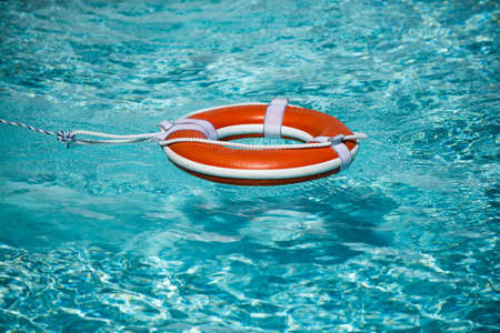 Preserver lifebuoy. Orange lifebuoy in sea on water. Life ring floating of water.