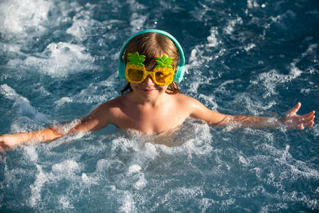 Close-up portrait of the cute boy swim and smiling in swimming pool.の写真素材