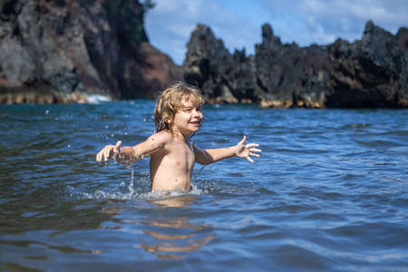 Happy boy playing and in swimming pool or sea water. Funny kids summer face.の写真素材