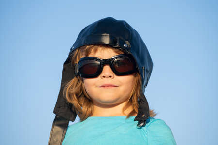 Kids dream. Caucasian child with pilot helmet and glasses, funny portrait close up. Kids face.の写真素材
